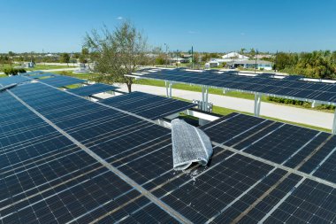 Park alanının gölgesinde, temiz enerjinin etkin üretimi için park etmiş arabaların güneş panellerine rüzgar hasarı.