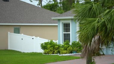 Florida 'da büyük pencereli ve bahçesinde yeşil çimenler olan tipik modern Amerikan özel evi.