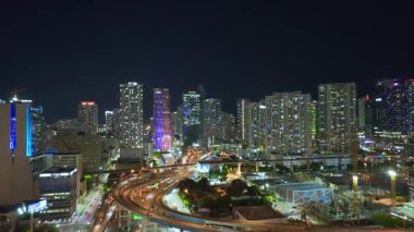 ABD ulaşım altyapısı konsepti. Miami City, Florida 'daki geniş otoyol kavşağının üzerinde gece hızlı giden arabalarla.