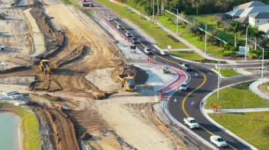 Kavşakta inşaat halindeki trafik arabalarını sürüyorlar. Amerikan yolunda hareket eden arabalarla trafik çemberi inşa etmek