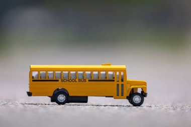 Açık havada Amerikan sarı okul otobüsünün küçük bir modeli. ABD 'de eğitim güvenliği kavramı.