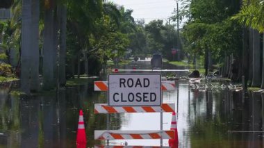 Florida 'da kasırga sonrası caddeyi su basmış. Kapalı levhalar araba sürmeyi engelliyor. Doğal afet konsepti sırasında ulaşımın güvenliği