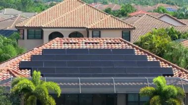 Banliyö bölgesinde temiz ekolojik elektrik enerjisi üretmek için güneş fotovoltaik panellerle kaplı çatısı olan bir ev. Özerk konut kavramı.