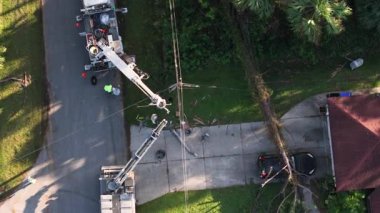 Florida banliyö bölgesinde meydana gelen kasırga sonrası hasar gören elektrik hatlarını onaran elektrik işçilerinin hava görüntüsü.