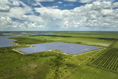 Temiz elektrik enerjisi üretmek için fotovoltaik panelleri olan tarımsal tarım arazileri arasında sürdürülebilir elektrik santralinin havadan görüşü. Sıfır emisyonlu yenilenebilir elektrik kavramı.