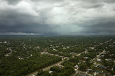 Kasaba üzerinde sağanak fırtınadan önce fırtınalı gökyüzünde oluşan kara uğursuz bulutların manzarası..