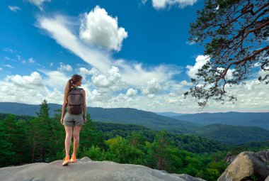 Yürüyüş yapan kadın dağ yolunda yürüyor ve doğanın tadını çıkarıyor. Issız yolda yalnız bir kadın gezgin. Sağlıklı yaşam tarzı kavramı.