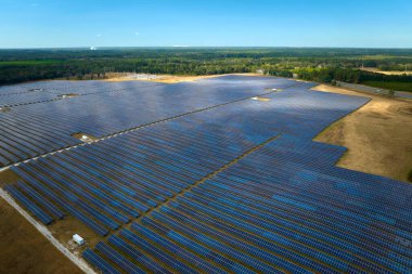 Temiz elektrik enerjisi üretmek için birçok sıra güneş fotovoltaik paneli bulunan sürdürülebilir büyük elektrik santralinin havadan görünüşü. Sıfır emisyon kavramı ile yenilenebilir elektrik.