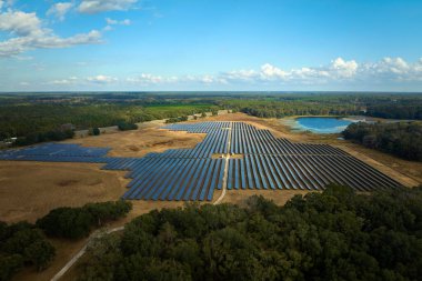 Temiz elektrik enerjisi üretmek için birçok sıra güneş fotovoltaik paneli bulunan sürdürülebilir büyük elektrik santralinin havadan görünüşü. Sıfır emisyon kavramı ile yenilenebilir elektrik.