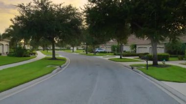 Araba bakış açısı. Florida kırsal kesimindeki evler arasında banliyö sokağında araba sürüyor. Ulaşım ve trafik kavramı