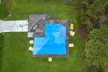 Ian Kasırgası 'nın çatısı, asfalt kiremitleri değişene kadar yağmur suyuna karşı mavi korumalı muşambayla kaplıydı..