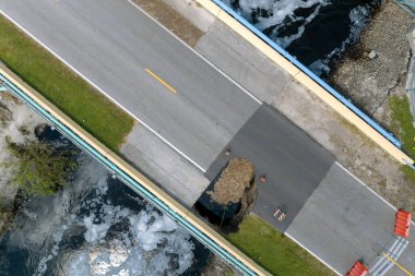Roadworks sitesi. Sel suları asfaltı yıkadıktan sonra yıkılan hasarlı yol köprüsünün yeniden inşası. Yıkılmış ulaşım altyapısının yeniden inşası.