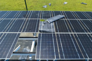 Park alanının gölgesine kurulmuş kasırga rüzgârlı güneş panelleri tarafından, temiz enerji üretimi için park edilmiş arabalar için tahrip edildi. Şiddetli hava şartlarının Florida altyapısına zararı.