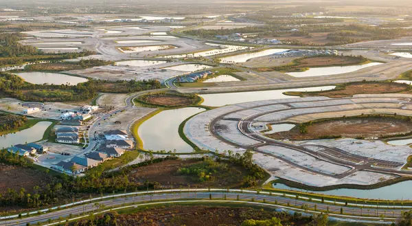 ABD 'de emlak piyasasının gelişimi. Amerikan kırsal kesiminde hazırlanmış topraklarda inşa ekipmanlarıyla büyük bir inşaat alanının havadan görüntüsü.