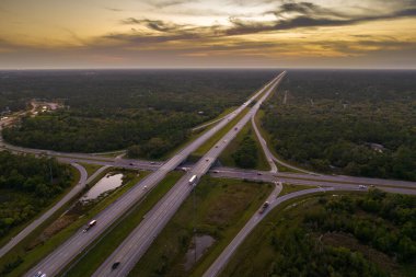 Florida kırsal kesişiminde gün batımında. Araç trafiğinin ekspres geçişi için yüksek şeritler.