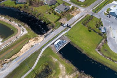 Hasarlı yol köprüsündeki barikat sel sularının asfaltı temizlemesinden sonra nehir tarafından tahrip edildi. Yıkılmış ulaşım altyapısının yeniden inşası.