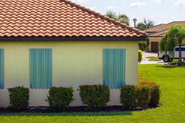 Kasırganın ev pencerelerini koruması için çelik çarşaflar, fırtına kepenkleri olarak monte edildi. Florida 'daki doğal felaketten önce koruyucu tedbirler.