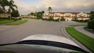 Araba sürücüsü. Ulaşım ve trafik kavramı. Florida yerleşim bölgesindeki apartmanlar arasında banliyö caddesinde araç sürüyor.