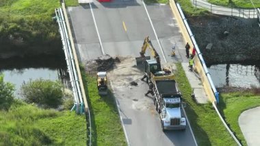 Yol yapımı. Florida 'daki asfaltı sel baskınından sonra yıkılan köprüyü onaran işçiler. Yol çalışması alanında inşaat ekipmanları