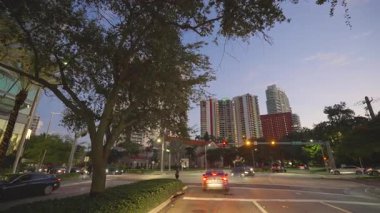 Gece Miami Beach, Florida 'da araba kullanırken görülmüş. Ulaşım ve trafik kavramı. Şehir caddesinde güney binaları arasında araç sürüyor.