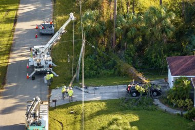 Elektrik işçileri kesintiden sonra elektrik hatlarını tamir ediyorlar. Florida banliyö bölgesinde kasırga sonrası hasar gören elektrik kablolarının tamiri.