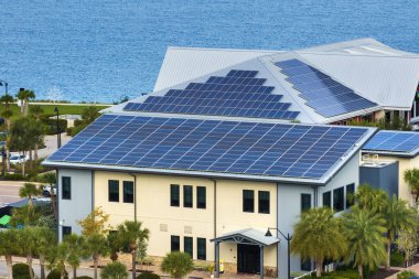 Solar çatılı Florida ofis binası. Temiz ekolojik elektrik enerjisi üretmek için mavi fotovoltaik paneller. Yenilenebilir elektrik kavramına yatırım.