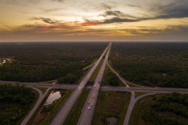 Florida kırsal kesişiminde gün batımında. Araç trafiğinin ekspres geçişi için yüksek şeritler.