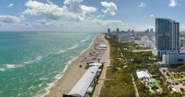 Güney Amerika 'da turizm altyapısı. Güney Sahili 'nin kumlu yüzeyi. Sıcak Florida güneşinde dinlenen turistler. Yüksek lüks otelleri ve apartmanları olan Miami Beach City..