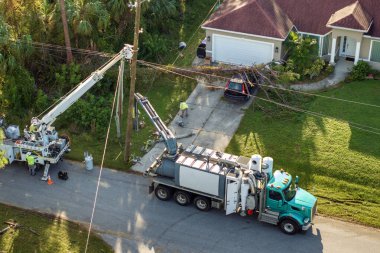 Florida 'daki kasırgadan sonra elektrik hatları tamir ediliyor. İşçiler konutlardaki elektrik kablolarını tamir etmek için kova kamyonları kullanıyorlar..