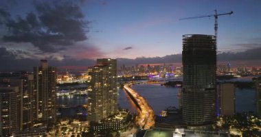 Amerikan kentsel bölgesindeki yeni yerleşim yerinin havadan görüntüsü. Geceleri Miami, Florida 'da endüstriyel inşaat alanında kule vinci. ABD 'de konut büyümesi kavramı