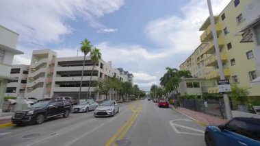 Miami Beach, Florida 'da Collins Bulvarı' nda araba kullanma. Ulaşım ve trafik kavramı. Şehir caddesinde güney binaları arasında araç sürüyor.