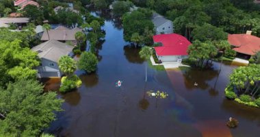 Doğal afet seli. Florida yerleşim bölgesindeki sel baskınından sonra sel basmış caddelerde yüzen kano tekneleri
