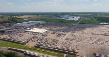 Otomotiv fabrikasındaki sanayi yük treni nakledilmeye hazır yeni arabalarla dolu. Satılık araçları olan otomobil üreticisi otoparkı