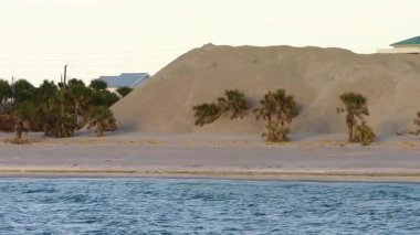 Manasota Key 'deki Englewood Sahili' ndeki Charlotte County kum alıcı bölgesinde Milton Kasırgası 'nın ardından temizlik yapılırken kum yığınları.