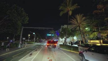 Gece Miami Beach Ocean Drive caddesinde POV sürüşü. Florida yolu trafiği hareketli