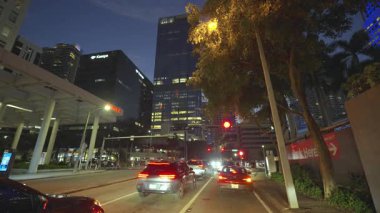 POV gece Miami caddesinde araba sürüyor. Florida yolu şehir merkezinde trafik var.