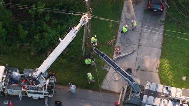 Florida 'daki kasırgadan sonra elektrik hatları tamir ediliyor. İşçiler konutlardaki elektrik kablolarını tamir etmek için kova kamyonları kullanıyorlar.