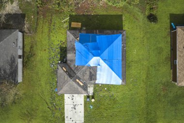 Ian Kasırgası 'nın çatısı, asfalt kiremitleri değişene kadar yağmur suyuna karşı mavi korumalı muşambayla kaplıydı..