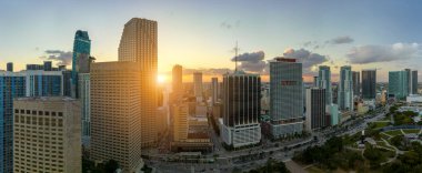 Miami Brickell 'in şehir merkezinin hava görüntüsü, Florida, ABD gün batımında. Modern Amerika 'da arabaları ve metro trafiği olan yüksek gökdelen binaları ve caddeleri.