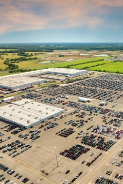 Yeni arabaların üretim fabrikasının otoparkında stokları var. Araçlar krupiye limanında arka arkaya park edilmiş. Otomotiv endüstrisi. Depoya yeni araba ithal veya ihraç et.