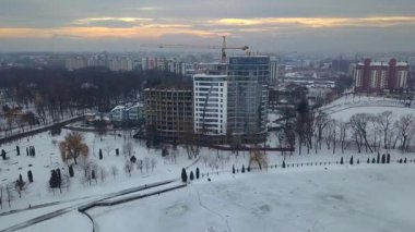 Yüksek modern konut binasının ve inşaat halindeki vinç kulesinin havadan görünüşü.