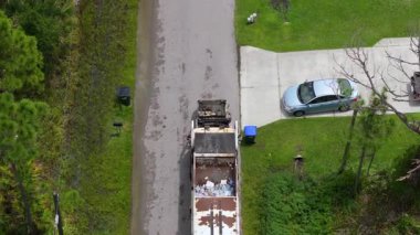 Otomatik modern çöp kamyonu Florida şehir caddesinde atık yüklüyor. Belediye hizmetleri