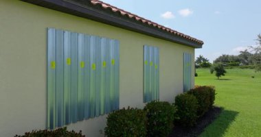 Kasırganın ev pencerelerini koruması için çelik çarşaflar, fırtına kepenkleri olarak monte edildi. Florida 'daki doğal felaketten önce koruyucu tedbirler.