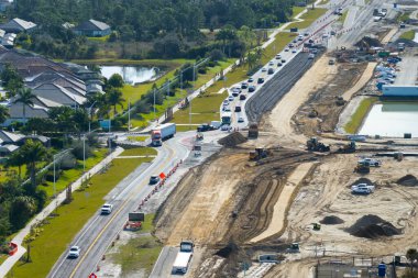 Kavşakta inşaat halindeki trafik arabalarını sürüyorlar. Amerikan yolunda hareket eden arabalarla trafik çemberi inşa etmek.