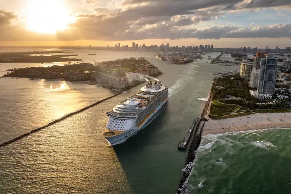 Büyük yolcu gemisi Miami limanında ana kanaldan ayrılıyor. South Beach yakınlarındaki lüks oteller ve apartmanlar..