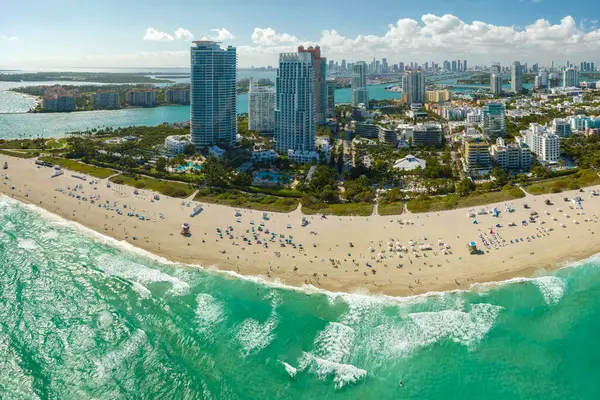 Güney Amerika 'da seyahat ve turizm altyapısı. Güney Sahili 'nin kumlu yüzeyi. Sıcak Florida güneşinde dinlenen turistler. Yüksek lüks otelleri ve apartmanları olan Miami Beach City..