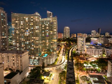 Miami, Florida, ABD 'nin modern şehir merkezinden geçen tren raylarının hava görüntüsü. Gece demiryolu üzerinde yüksek binalar..