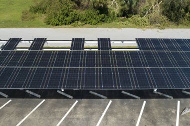 Park alanının gölgesine kurulmuş kasırga rüzgârlı güneş panelleri tarafından, temiz enerji üretimi için park edilmiş arabalar için tahrip edildi. Şiddetli hava şartlarının Florida altyapısına zararı.