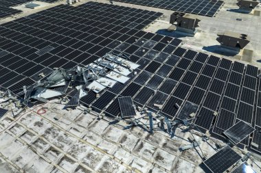 Fırtınalar tarafından yıkılan fotovoltaik güneş panelleri yeşil ekolojik elektrik üretmek için endüstriyel binaların çatısına monte edildi. Florida 'daki doğal afet sonuçları.