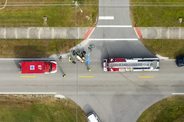 Amerikan caddesindeki sağlık görevlileri sedyesinde trafik kazası kurbanı. İlk müdahale ekipleri ve acil tıp teknisyenleri ABD 'de trafik kazasında bisikletçiye yardım ediyor..